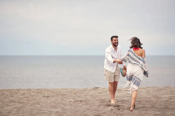年轻夫妇在阳光明媚的海滩上玩得很开心 — 图库照片