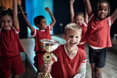 Küçük futbolcular soyunma odasında zaferi kutluyorlar.