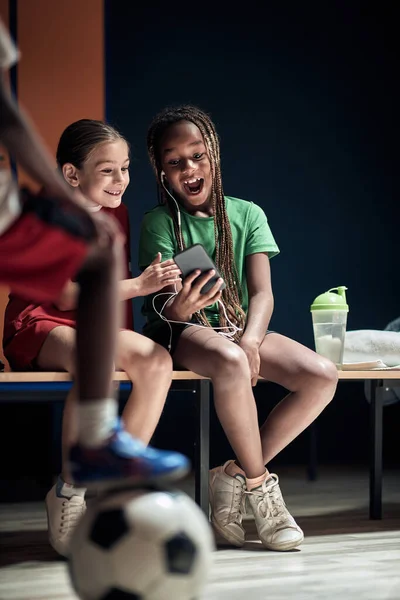 Små Fotbollsspelare Ett Omklädningsrum Glada Över Mobilinnehåll — Stockfoto