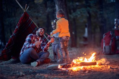 Babam çocuklarla kampta oynuyor, kaliteli aile zamanı konsepti.