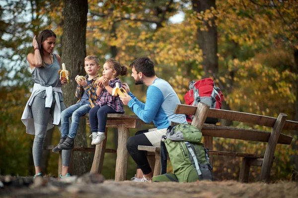 A family having a snack together in the woods