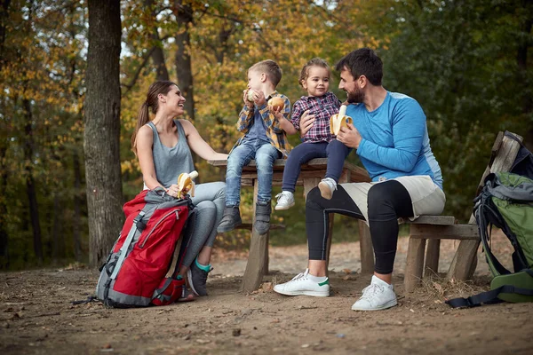 Happy family having a snack together in the woods; Spring or autumn hiking in nature; camping, travel, tourism,lifestyle,  hike and people concept. Quality active family time together.