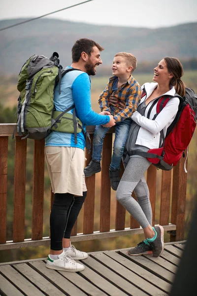 Happy couple with a son on a hiking adventure; Spring or autumn hiking in nature; camping, travel, tourism,lifestyle,  hike and people concept. Quality active family time together.