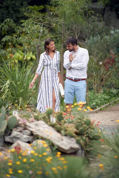 植物園の植物についてのリラックスした会話の中で若い女性ガイドと若い男性の訪問者 — ストック写真