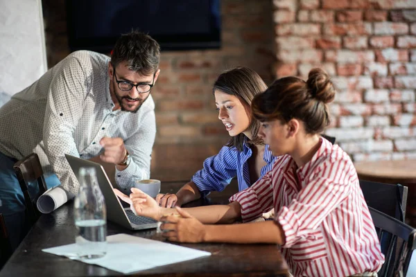 A young couple and a waitress enjoying laptop content