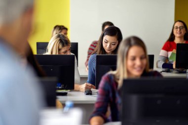 Üniversite bilgisayar sınıfındaki bilgilendirme dersinde çalışan bir atmosfer. Zeki gençler üniversitede okuyor. Eğitim, üniversite, üniversite, öğrenim ve insanlar konsepti