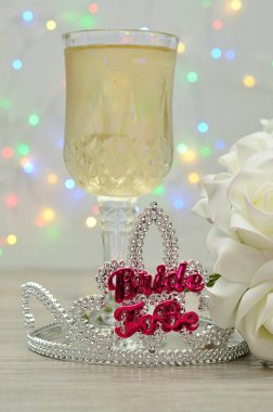 Bir kadeh şampanya ve bir buket gül ile görüntülenecek kelime gelinle bir taç