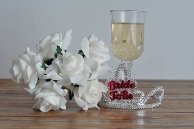 Bir kadeh şampanya ve beyaz güller ile görüntülenecek kelime gelinle bir taç