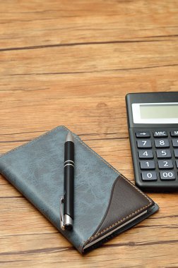 Bir defter ve bir kalem ile görüntülenen bir hesap makinesi