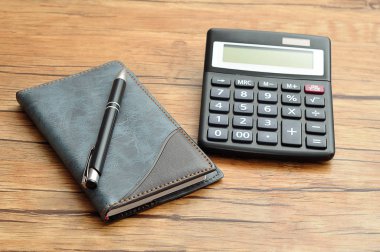 Bir defter ve bir kalem ile görüntülenen bir hesap makinesi