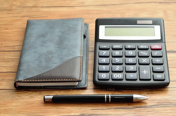 Bir defter ve bir kalem ile görüntülenen bir hesap makinesi