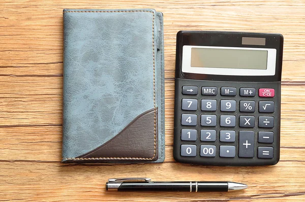 Bir defter ve bir kalem ile görüntülenen bir hesap makinesi