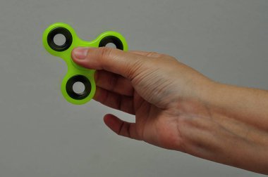 Yeşil topluca spinner tutan bir el