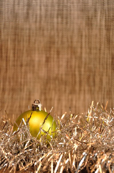 Uma Única Bugiganga Natal Verde Com Ouropel Prata Contra Fundo — Fotografia de Stock