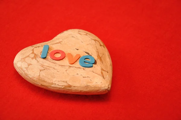 Słowo Miłość Górze Drewniane Serca Białym Tle Czerwonym Tle — Zdjęcie stockowe