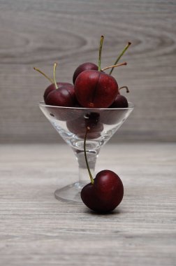 Ahşap bir arka plan ile bir cam kase kiraz