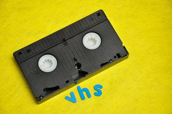 在黄色背景上与 "Vhs" 号隔离的录像带 — 图库照片