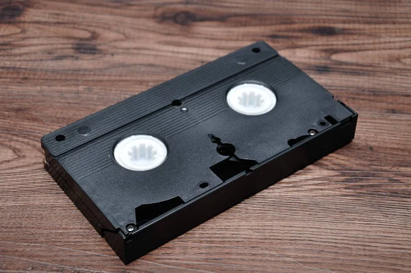 Een videocassette geïsoleerd op een houten achtergrond — Stockfoto