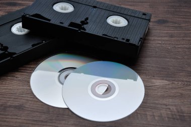 Cd ile ahşap bir arka plan üzerinde izole iki video kasetleri