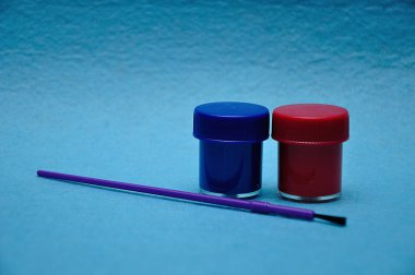 Mavi arka plan üzerinde mor bir fırça ile boya iki tencere