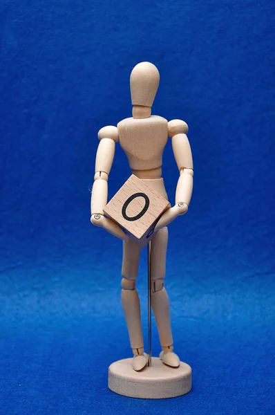 A wooden mannequin with a wooden block with the number zero — Stock Photo, Image