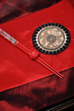 Kırmızı bir masa bezi üzerinde birlikte bir çift kırmızı Chopsticks bağladı