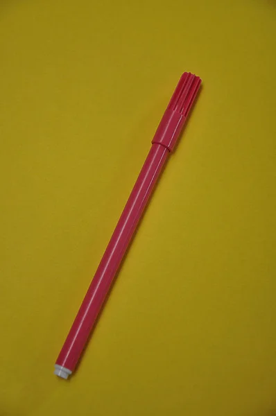 黄色の背景に孤立したピンクのペン — ストック写真