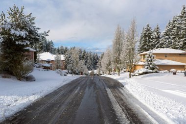 Mutlu Vadi Oregon 'da bir kış kar günü boyunca buzdan arındırılmış tuzla kaplı banliyö mahallesi caddesi