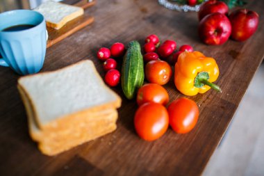 Taze domates, turp, salatalık, elma lezzetli yemek için. Olgun meyve ve sebze ahşap mutfak masasında yalan
