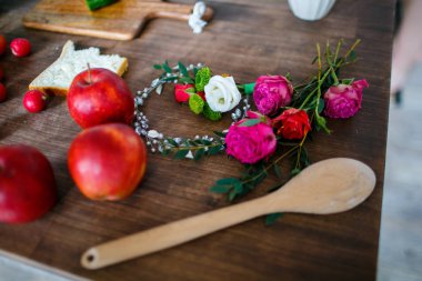 Beyaz, kırmızı ve pembe gül ahşap mutfak masasında. Olgun meyve ve sebze