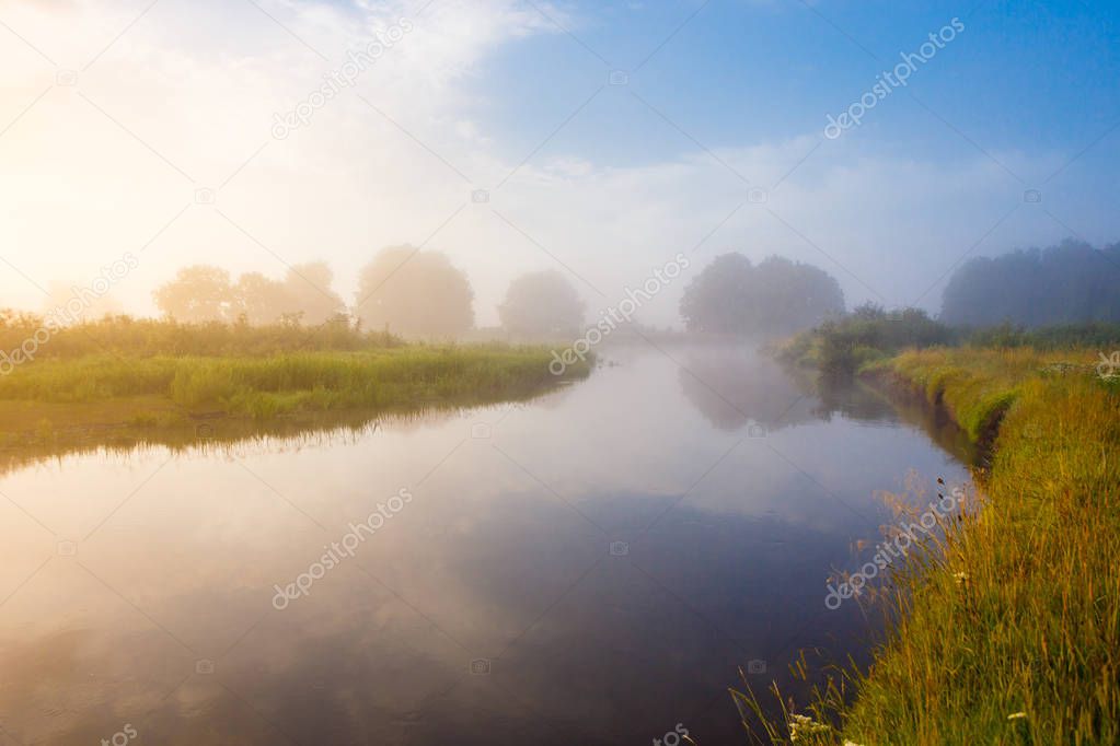 Sunny morning over foggy countryside and river in bright sunlight