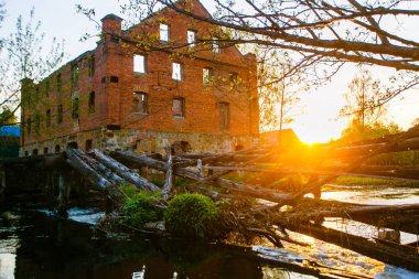 Kırmızı tuğla küçük bir köy bina. Parlak Güneş ufukta
