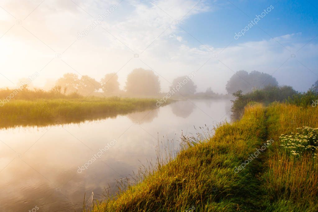 Peaceful sunrise, foggy river in quiet rural area