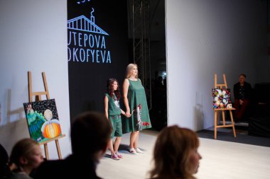 Minsk, Beyaz Rusya - 7 Kasım 2018: Anne ve kızı piste Beyaz Rusya moda haftasında poz. Çocuklar moda gün. Keten giysiler giyiyor insanlar