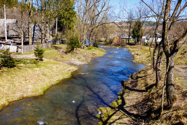 Dağlık Nehri akan ile küçük bir köy. Erken bahar
