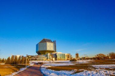 Mavi gökyüzü ve güneş Minsk'te Milli Kütüphane üzerinden parlıyor