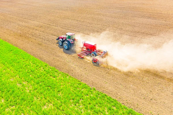 Agriculture on farmland. Red tractor ploughing soil in spring — Stock Photo, Image