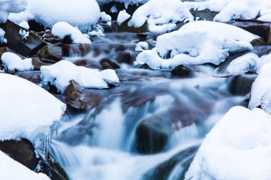 Water cascades in mountains long exposure. Snowy weather concept