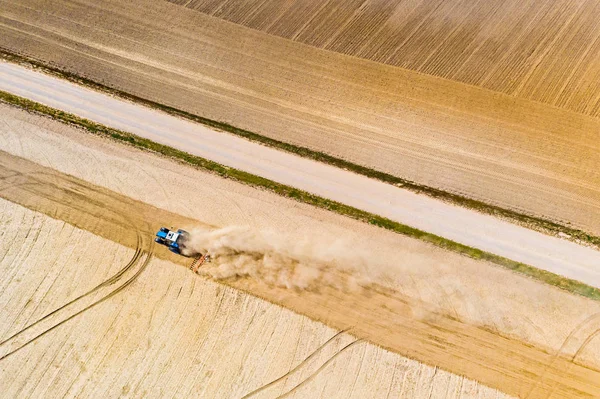 Tractor cultivates dry farmlands, aerial landscape. Track on soil patterns — Stock Photo, Image