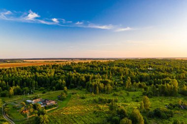 Ormanın ve mavi gökyüzünün arka planında küçük bir köy. Küçük vatan kavramı.