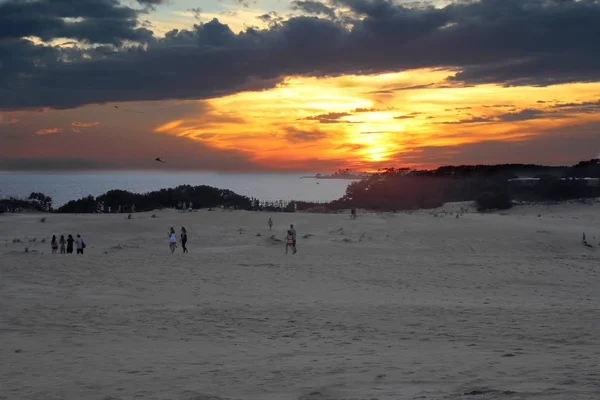 在美国东部最高的活跃沙丘 Jockeys Ridge State 当太阳落山时 人们走在沙滩上 — 图库照片