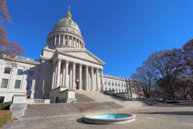 Ön girişi ve kubbe Charleston Kanawha Nehri boyunca bir yıkım karşı bina Batı Virginia Capitol sonbahar gökyüzü mavi