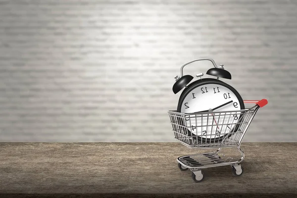 Alarm clock in shopping cart on wooden desk, bricks wall. — Zdjęcie stockowe
