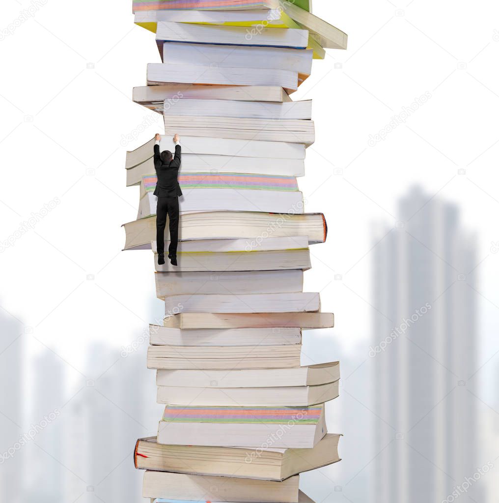 High stack of books with climbing businessman hang on it