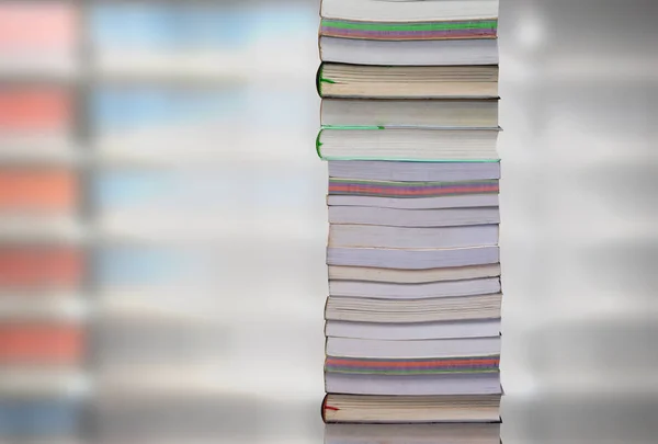 Stacking books with blur bookshelfs background in library room. — Stock Photo, Image