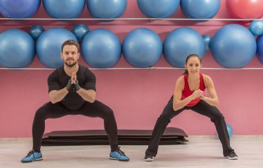 Bir spor salonunda germe egzersizleri yaparken Genç çift