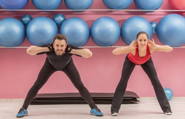 Bir spor salonunda germe egzersizleri yaparken Genç çift