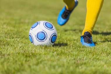 Yakın çekim yansıma ayak topu tekmeleme bir futbol oyuncusu. Odak topa.