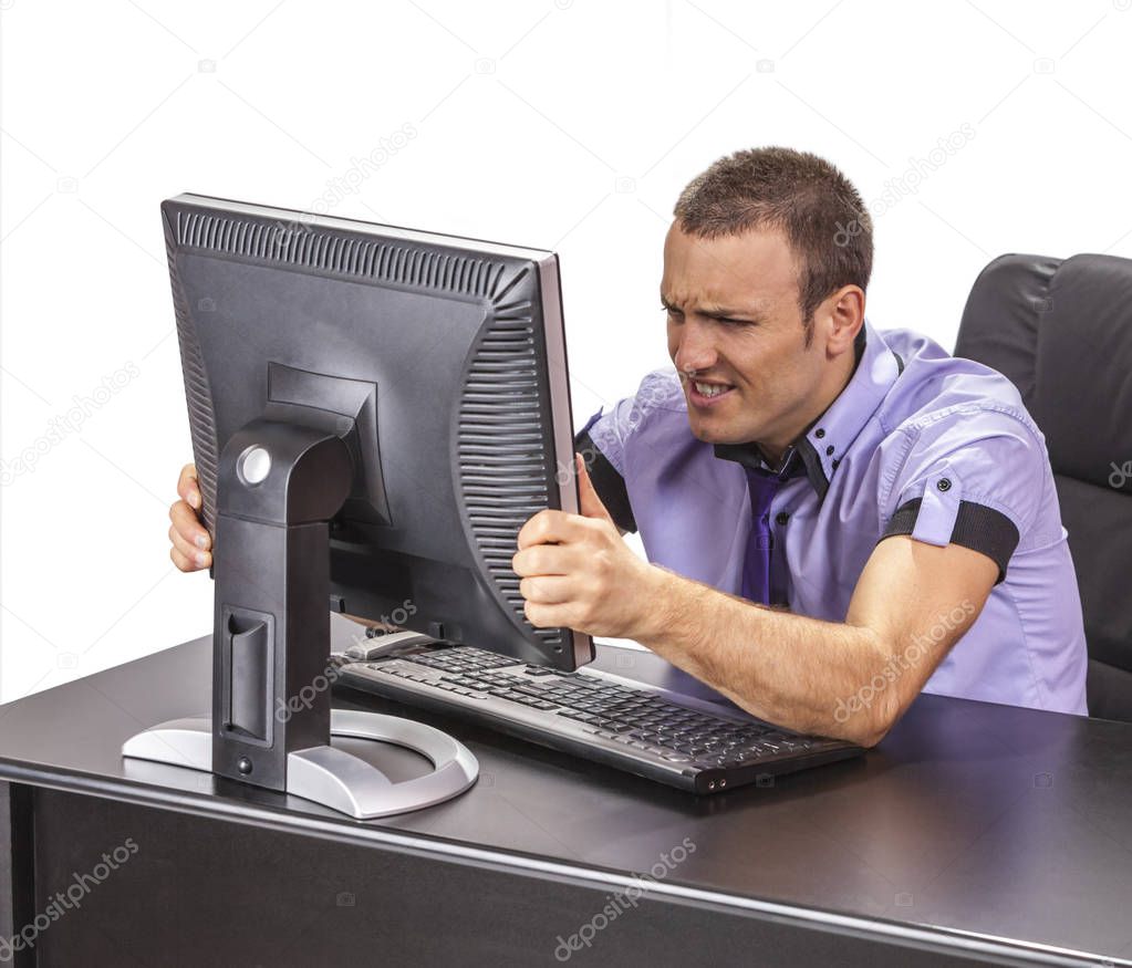 Young man angry with the computer at his workplace.