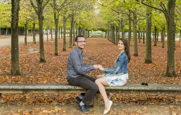 秋の公園の石のベンチに一緒に楽しみを持つ素敵なカップル — ストック写真